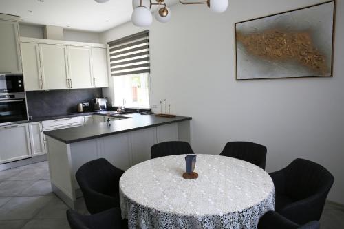 a kitchen with a table with chairs and a counter at Lauras Apartment in Bauska