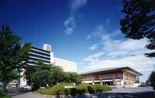 a large building with a clock tower on top of it at ホテルグランド東雲 in Tsukuba