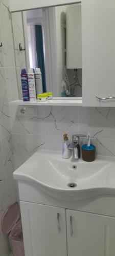 a bathroom with a white sink and a mirror at Lovely Apartment in City Center in Batumi