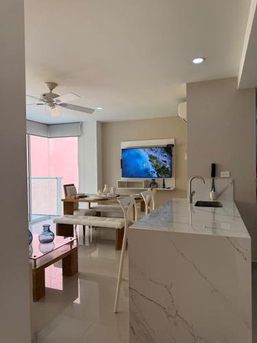 a kitchen and dining room with a table and a tv at Morros 922 Beach House in Cartagena de Indias