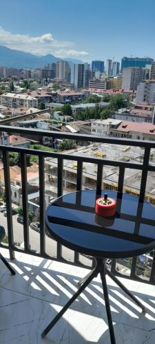 a table on a balcony with a view of a city at Lovely Apartment in City Center in Batumi