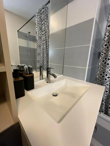a white sink in a bathroom with a shower at Toulouse Coconing & Peaceful Apartment in Toulouse