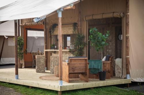 a tent with a wooden porch with a table at Camping Site de Gorge Vent in Fréjus