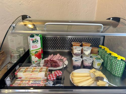 a refrigerator with some food and other food items at Gite Clé des Champs in Montenois