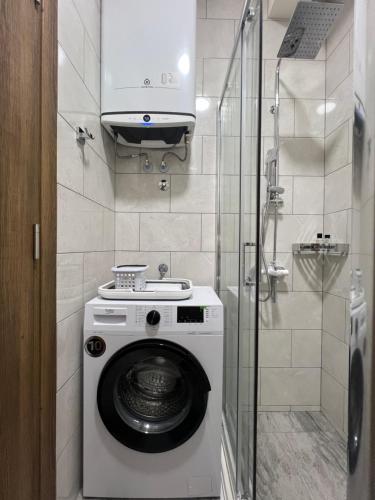 a washing machine in a bathroom with a shower at DIS LUX Apartments in Radanovići