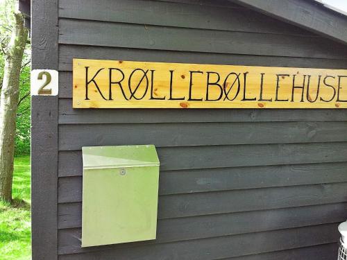 a sign on the side of a building with a trash can at 4 person holiday home in Allinge in Allinge