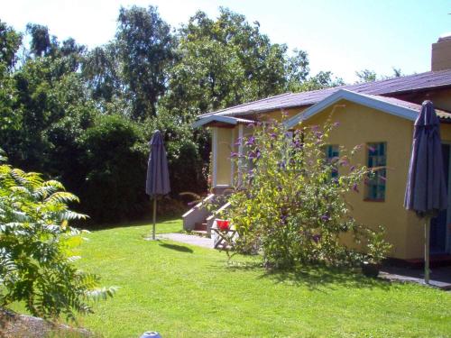 a house with two umbrellas in a yard at 4 person holiday home in Allinge in Allinge
