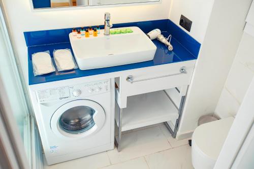 a bathroom with a sink and a washing machine at PANORAMA LUXURY ORBI CITY Aparthotel in Batumi