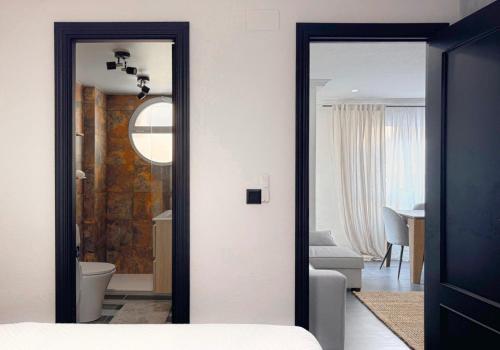 グアルダマル・デル・セグラにあるSeaside Apartment, 2 Bedrooms Guardamarの鏡付きのベッドルーム1室、ベッド付きのベッドルーム1室が備わります。