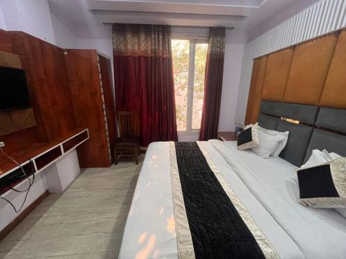 a bedroom with a large bed and a large window at Haveliya Homes- Just 1 minute from Railway Station and Connaught place in New Delhi