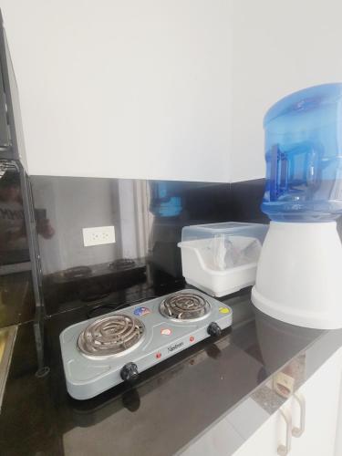 a kitchen with a stove and a bowl on the counter at Ilocos Norte Staycation in Laoag in Laoag