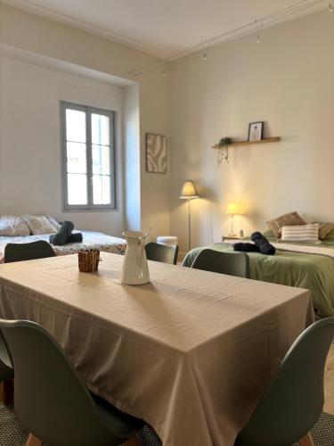 a room with a table with chairs and two beds at Appartement 6 personnes Paray-le-monial in Paray-le-Monial