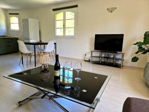 a living room with a table with wine glasses and a tv at Villa Ohna - Gîte Romantique avec Spa Privé in Vals-les-Bains
