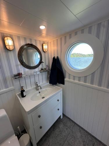 a bathroom with a sink and a round window at Backstugan - litet hus med storslaget läge in Västra Frölunda