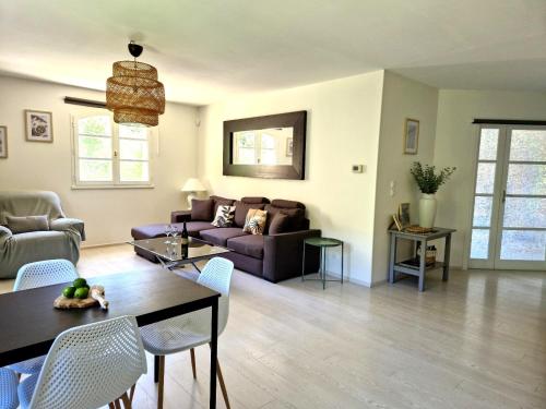 a living room with a couch and a table at Villa Ohna - Gîte Romantique avec Spa Privé in Vals-les-Bains