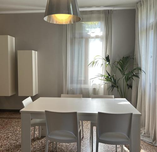 a white dining room table with chairs and a window at Villa Moro Lin Design Apartments in Mestre