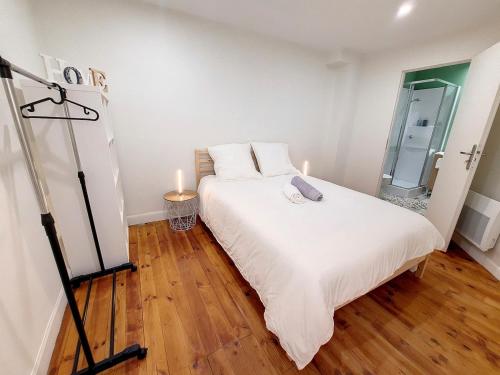 a bedroom with a white bed with two candles on it at Les Arcades - Mirande Centre in Mirande