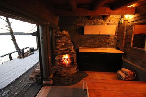 a fireplace in a log cabin with a stove at Vietos Villa 