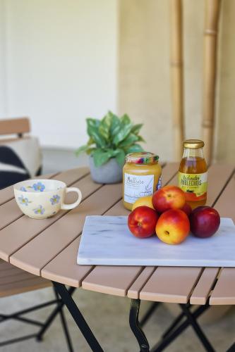 a table with a plate of apples and a jar of honey at Villa Ohna - Gîte Romantique avec Spa Privé in Vals-les-Bains
