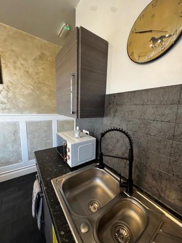 a kitchen with a sink and a clock on the wall at Central Sheffield 3-Bed Apt Sleeps 6 with Parking in Sheffield
