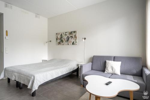 a room with a bed and a couch and a table at Holiday in Lapland - Ylläs Sivulantie 106 in Äkäslompolo
