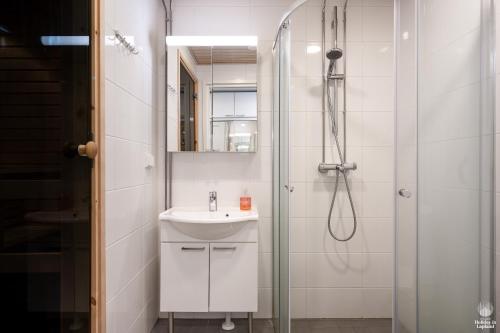 a white bathroom with a sink and a shower at Holiday in Lapland - Ylläs Sivulantie 106 in Äkäslompolo