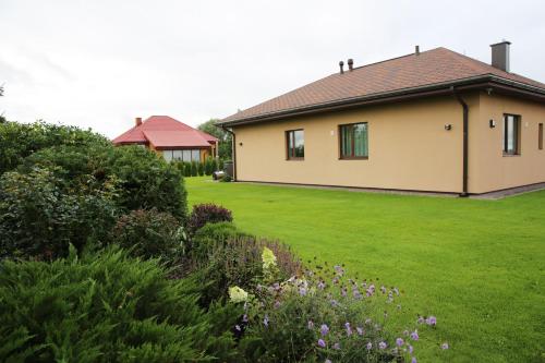 a house with a green yard with flowers at Lauras Apartment in Bauska