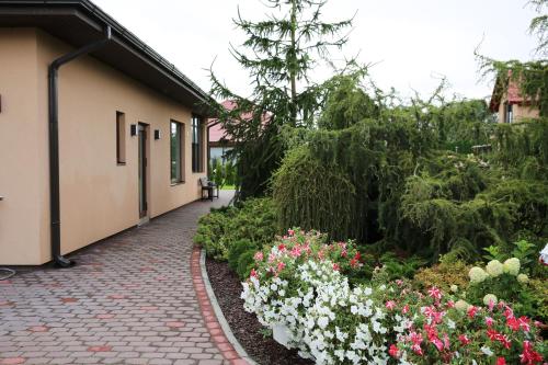 a garden of flowers next to a building at Lauras Apartment in Bauska