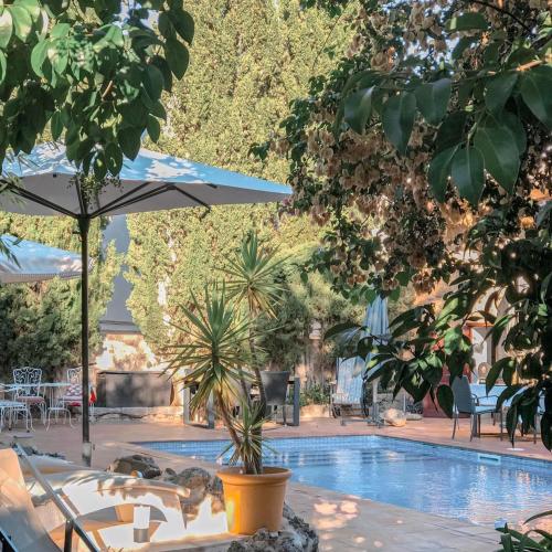 a swimming pool with chairs and umbrellas and trees at Suites with pool in Can Fressa Garden - Only Adults in Alaró