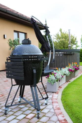 a bbq grill on a patio with flowers at Lauras Apartment in Bauska