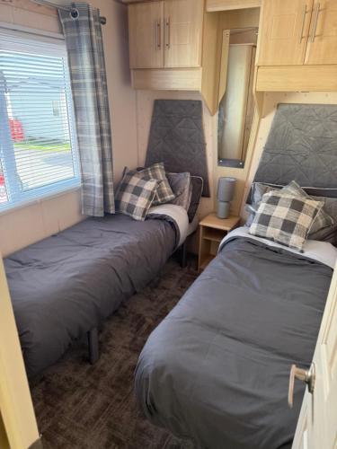 two beds in a small room in a caravan at Caravan by the sea in Gristhorpe