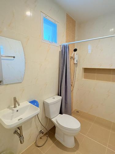 a bathroom with a white toilet and a sink at Cozy House Chanthaburi in Chanthaburi