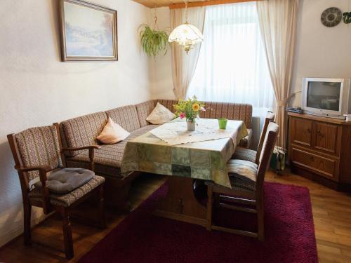 a living room with a table and a couch at Hontheim Farmhouse Retreat in Sellerich