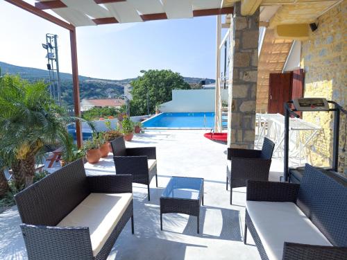 a patio with tables and chairs and a swimming pool at Villa Olive Tree with Private Pool in Kissamos