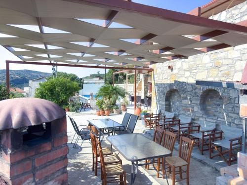 a patio with tables and chairs and a stone wall at Villa Olive Tree with Private Pool in Kissamos