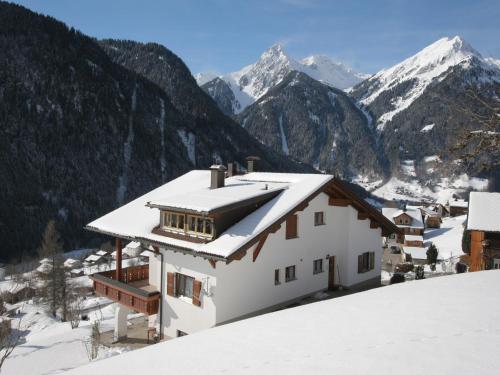 ein Haus im Schnee mit Bergen im Hintergrund in der Unterkunft Apartment in Sankt Gallenkirch near Ski Area in Sankt Gallenkirch