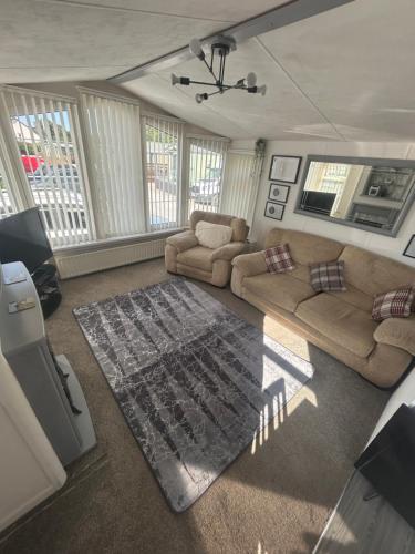 a living room with two couches and a rug at Western Lakes Caravan in Lamplugh
