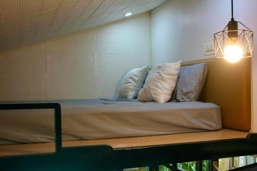 ein Bett mit drei Kissen darauf in einem Zimmer in der Unterkunft Kamia Tiny Rest House in Santa Rosa