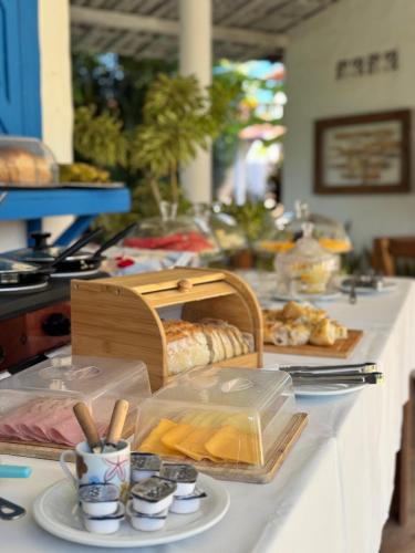 a table with bread and other food on it at Pousada Ilha do Vento in São Miguel do Gostoso