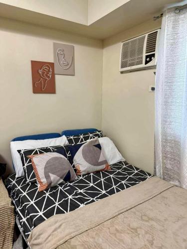 a small bed in a room with a window at Savannah Staycation in Davao City
