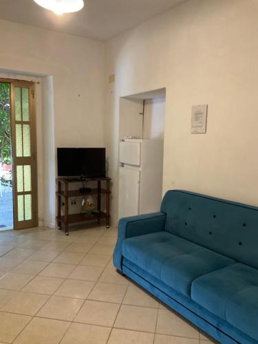 sala de estar con sofá azul y nevera en Le Querce 2, en Paola