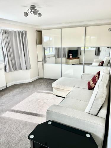 Una sala de estar con un sofá y un televisor. en Wonderful two bedroom bungalow in Oxford, en Kidlington