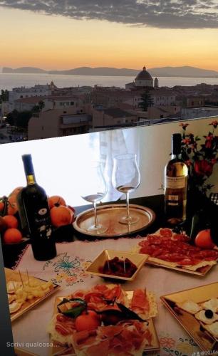 a table with plates of food and bottles and wine glasses at B&B Su Canistreddu in Alghero