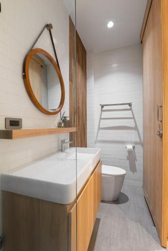 a bathroom with a sink and a toilet and a mirror at Sense Pool Villa HuaHin - 4BR&BBQ, 5 Min Walk to the Beach in Hua Hin
