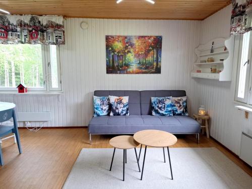 a living room with a blue couch and a table at WOLF Lakeside Cabins Lapland in Rovaniemi