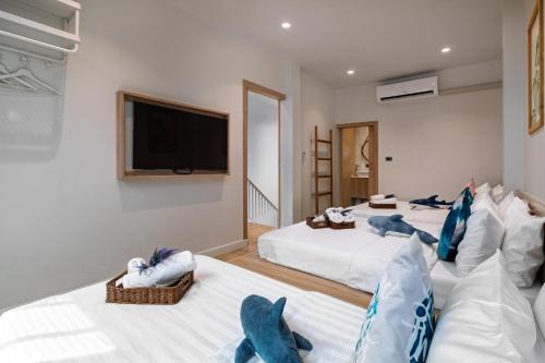 a room with two beds and a flat screen tv at Sense Pool Villa HuaHin - 4BR&BBQ, 5 Min Walk to the Beach in Hua Hin