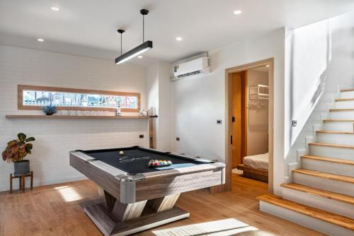 a pool table in a living room with stairs at Sense Pool Villa HuaHin - 4BR&BBQ, 5 Min Walk to the Beach in Hua Hin