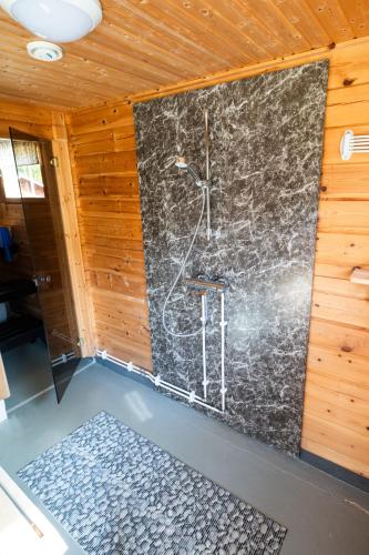 a bathroom with a shower in a wall at Poromoision pirtti in Peurasuvanto