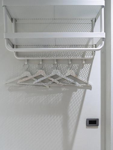 an open refrigerator with white shelves and hangers at Sense Pool Villa HuaHin - 4BR&BBQ, 5 Min Walk to the Beach in Hua Hin