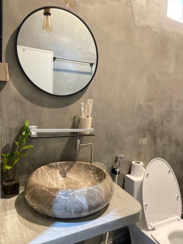 a bathroom with a stone sink and a mirror at Mother’s House in Battambang